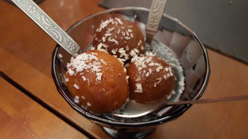 Gulab jamun: bolinhos fritos de leite em pó com calda morna de água de rosas e cardamomo. Delicioso!