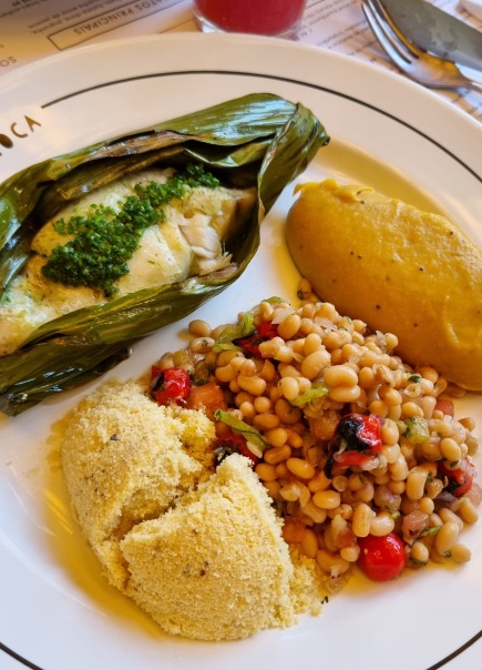 Suculento peixe na folha de bananeira com purê de banana-da-terra, salada de feijão-manteiguinha e farofa de castanha-do-pará!