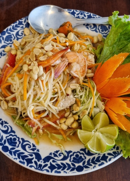 Som Tam: salada de mamão verde, tomate, vagem, alho, limão, açúcar de palmeira, pimenta, molho de peixe e amendoim torrado